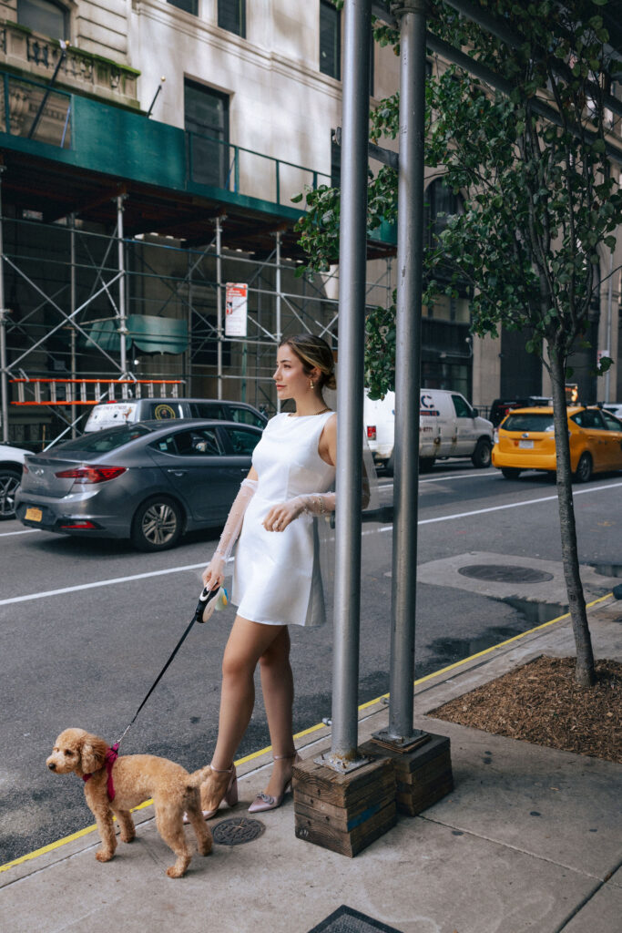 Bride with her puppy in front of the Arlo NoMad Hotel, capturing a chic and joyful moment before her wedding in NYC
