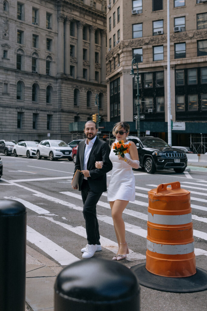 Couple walking together in downtown Manhattan on their way to City Hall, capturing a romantic pre-wedding moment in NYC