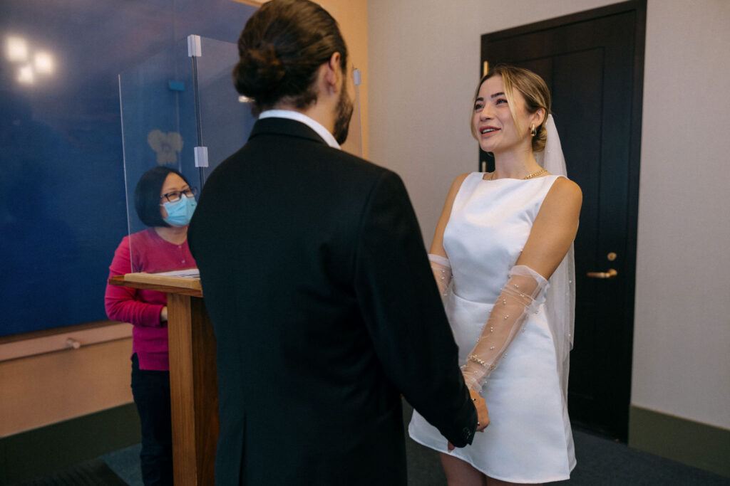 Couple standing hand-in-hand at their City Hall wedding in Manhattan, NYC, capturing a tender and romantic ceremony moment
