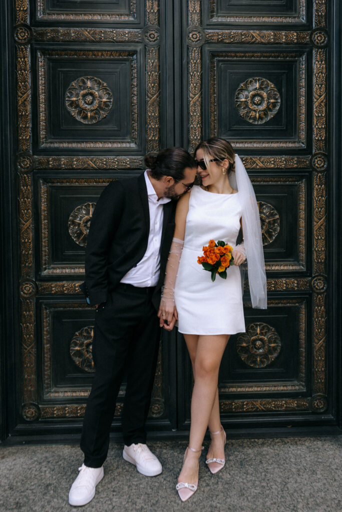 Couple posing for a romantic photoshoot in downtown Manhattan after their City Hall wedding, capturing candid moments in the city.