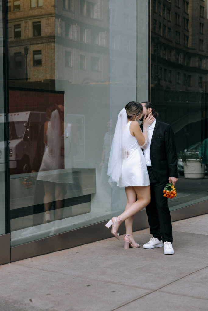 Couple sharing a kiss by Grand Central Terminal, capturing a romantic moment amid the iconic architecture of NYC.
