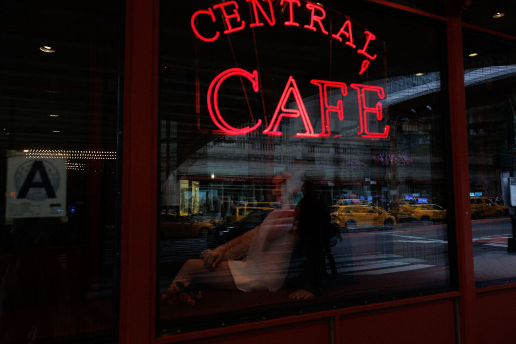 Newlyweds captured in a cinematic shot at Central Café, enjoying a romantic moment together in a vibrant NYC setting.