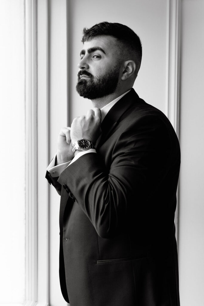 Groom preparing for his romantic wedding, captured in a candid, documentary-style moment, highlighting elegance and anticipation
