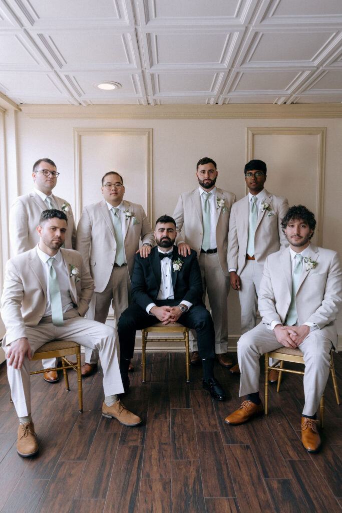 Groomsmen posed in a casual, relaxed stance, laughing and enjoying a candid moment together before the wedding ceremony.
