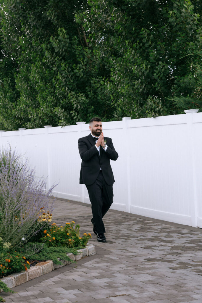 Candid first look moment as the groom sees his elegant bride, capturing the excitement and romance of their luxury wedding.
