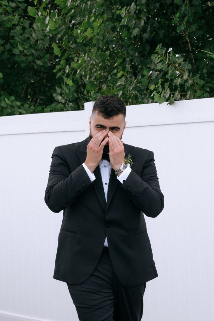 Groom's joyful reaction during the first look with his bride, highlighting a tender, documentary-style moment before the wedding ceremony
