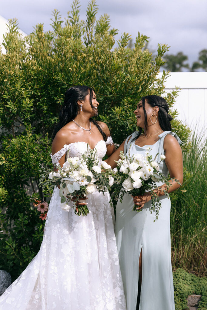 Candid shot of bride and friend embracing, capturing a heartfelt moment before the wedding celebration
