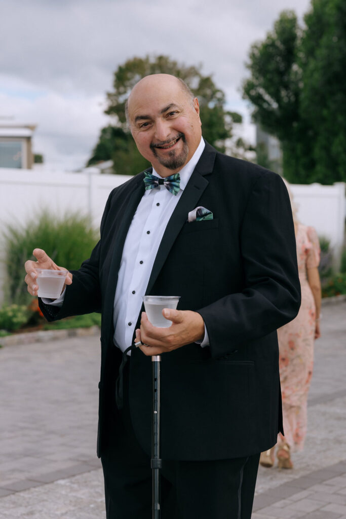 Wedding guests arriving at the ceremony, captured in a candid, documentary-style moment, showcasing excitement and anticipation
