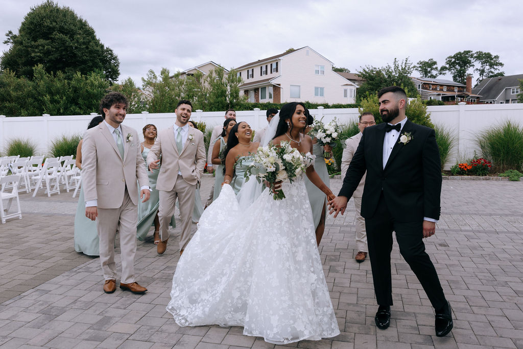 Bridal party laughing together in a relaxed, candid pose, capturing the fun and excitement before the wedding ceremony.
