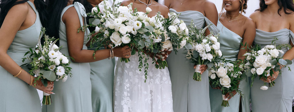 Bride surrounded by her bridesmaids and elegant bouquets, highlighting friendship and celebration in a documentary-style wedding shot