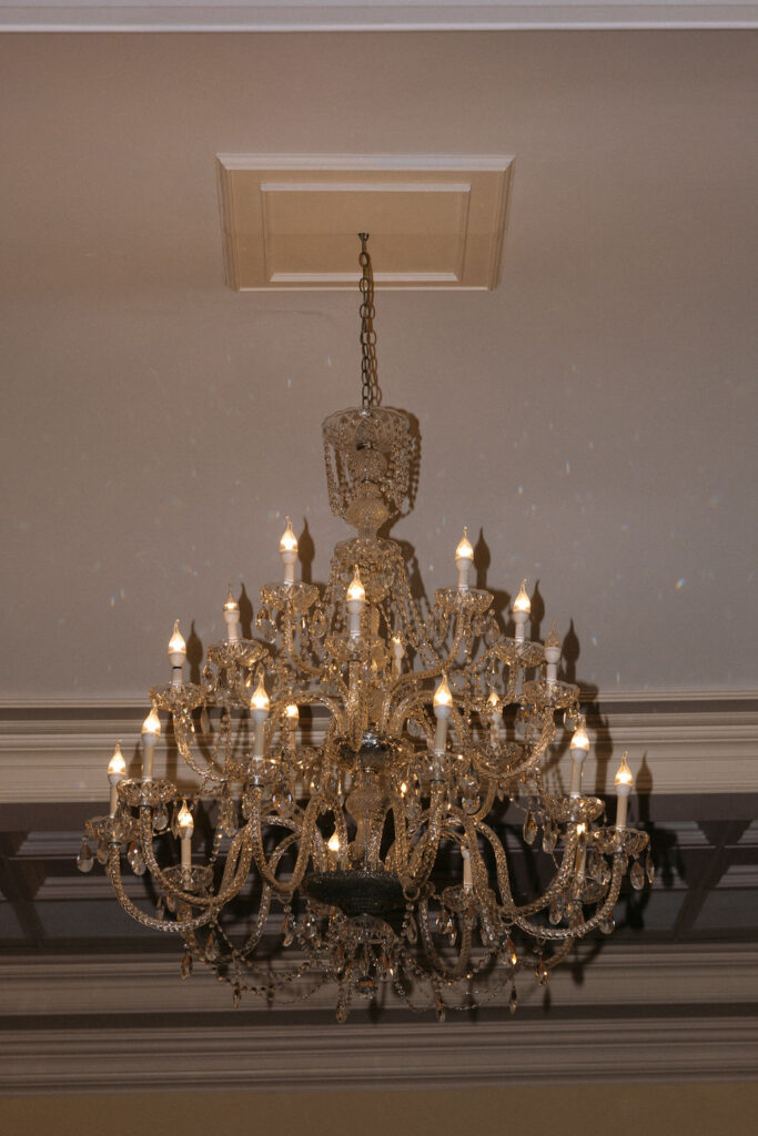 Stunning chandelier casting soft, elegant light, adding a touch of luxury and sophistication to the wedding venue decor
