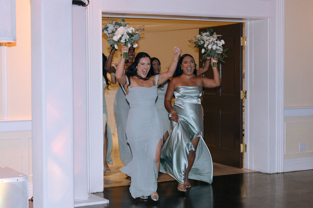 Bridal party making a lively entrance at the wedding reception, filled with excitement and joyful energy, setting a celebratory tone for the evening
