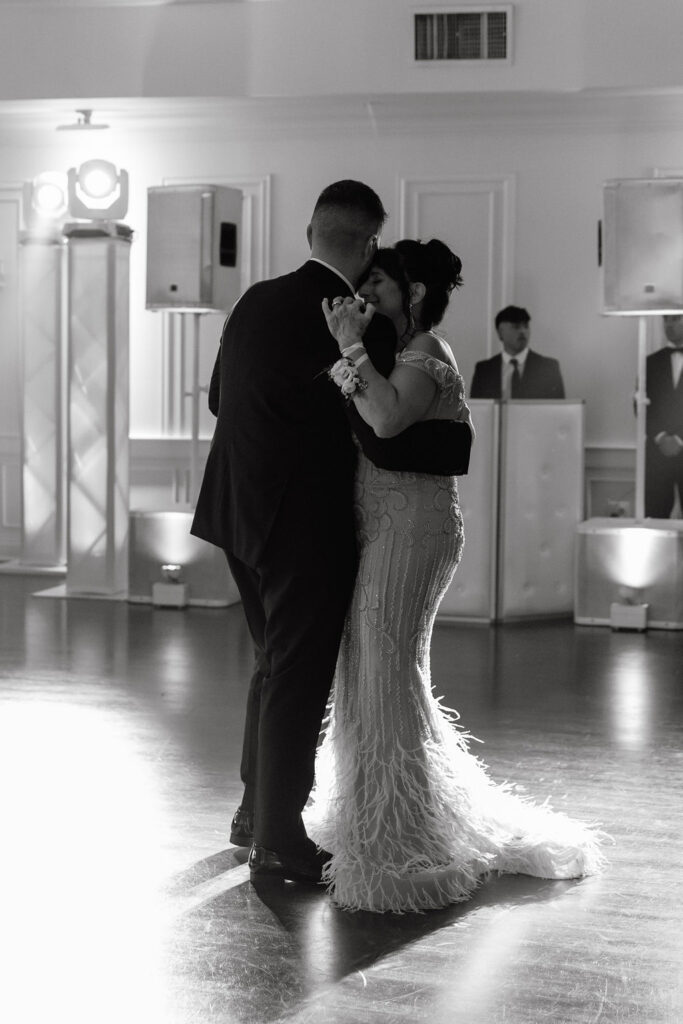 Emotional moment of the groom dancing with his mom, surrounded by love and joy on the dance floor