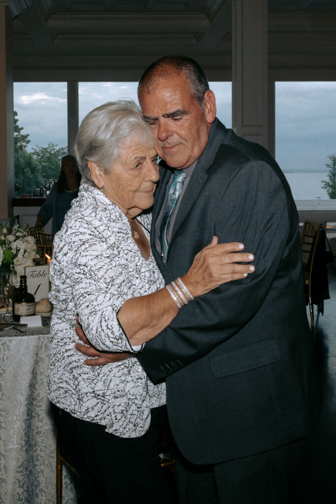 Grandparents joyfully dancing on the wedding dance floor, showcasing their love and excitement as they celebrate with family