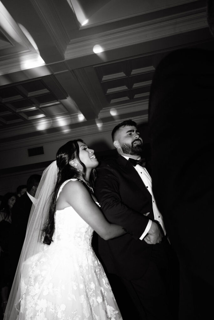 Bride and groom sharing a romantic dance, surrounded by love and joy during their wedding reception.