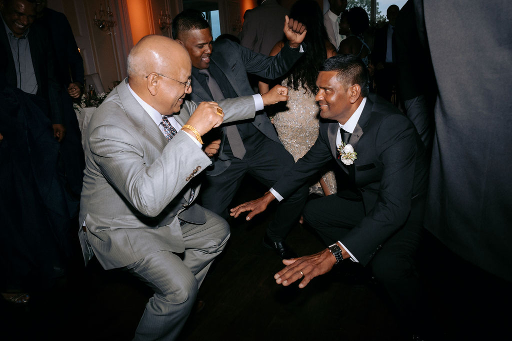 Groom's father dancing with guests on the wedding dance floor, showcasing a fun and lively atmosphere filled with laughter and celebration