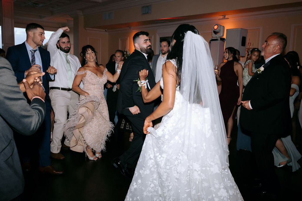 Vibrant wedding dance floor filled with guests dancing and celebrating, showcasing the joyful atmosphere of the reception