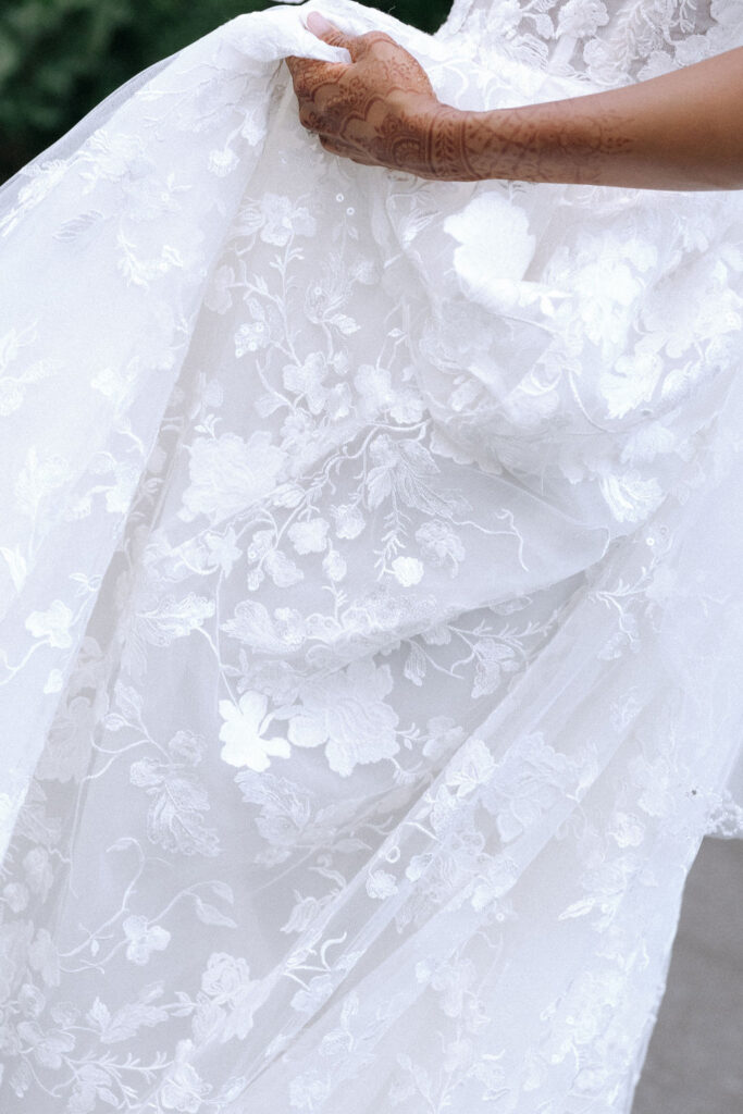 Intricate details of the wedding dress, showcasing delicate lace and embellishments that enhance the bride's elegance.