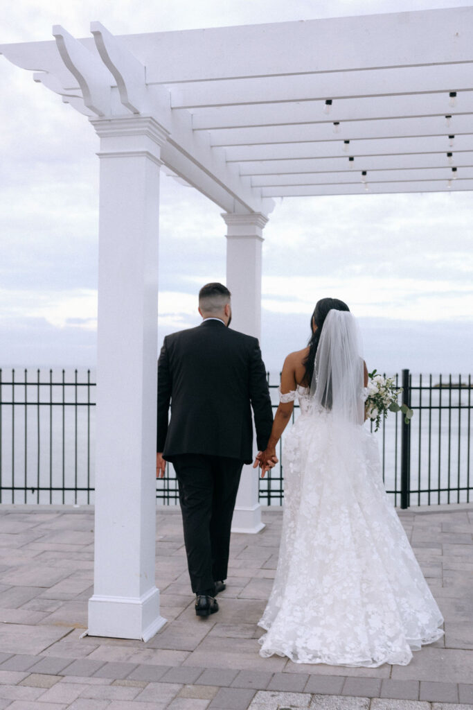 Couple walking hand-in-hand, enjoying a romantic moment together during their wedding day.