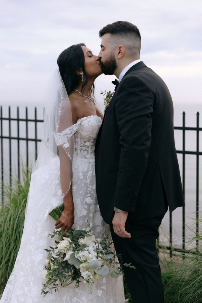 Couple sharing a romantic kiss, capturing a heartfelt moment of love and joy on their wedding day.