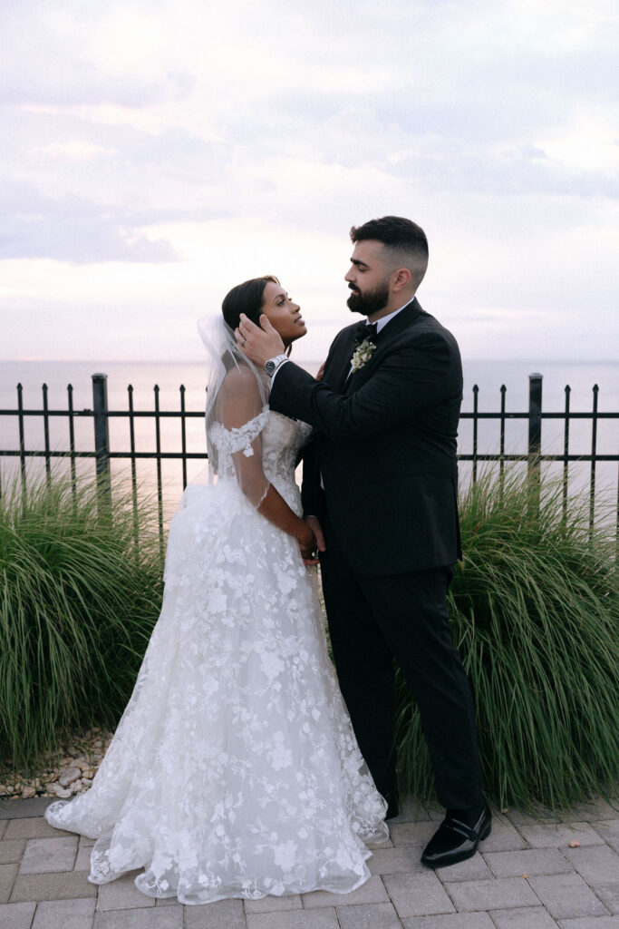 Groom gently touching the bride's face, capturing a tender and intimate moment filled with love on their wedding day