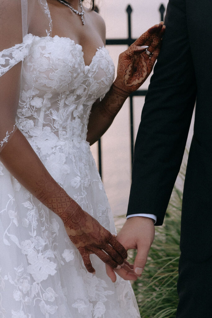 Bride and groom's hands intertwined, symbolizing their love and unity on their wedding day