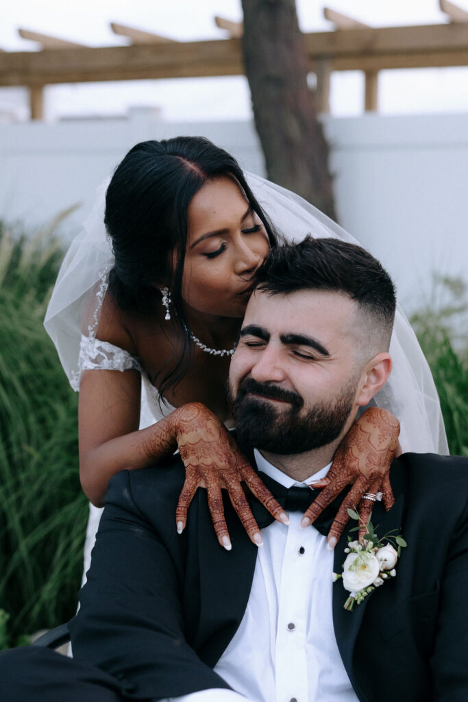 Bride kissing the groom, capturing a tender and joyful moment filled with love on their wedding day.