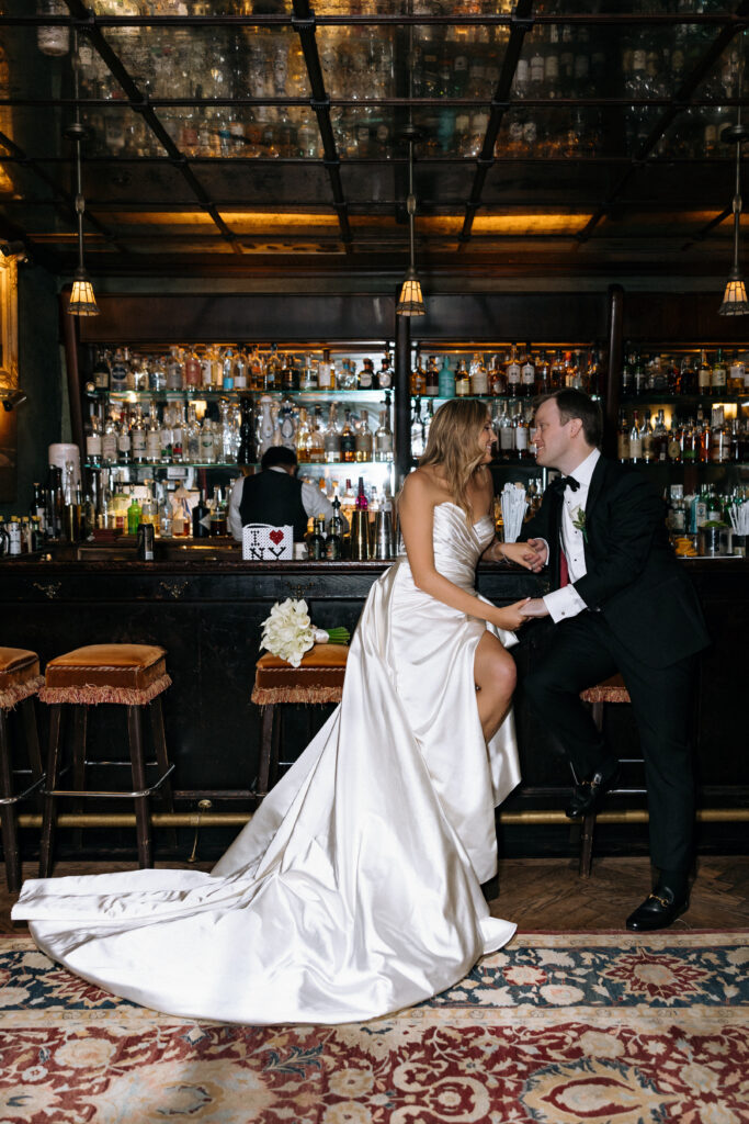 Elegant bride and groom sharing a romantic moment at the Bowery Hotel bar, with vintage decor and a warm ambiance setting the scene for timeless wedding memories