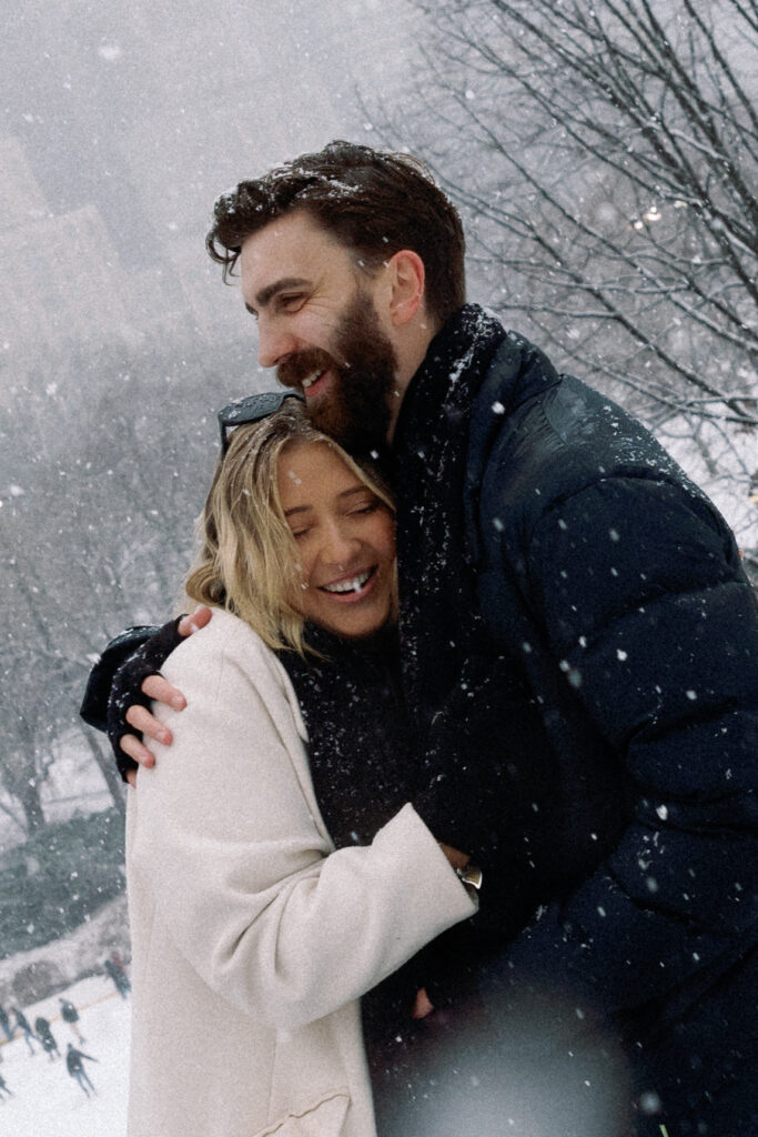 Fiancée laughing with her head resting on her fiancé's chest after their engagement, capturing a joyful and intimate moment