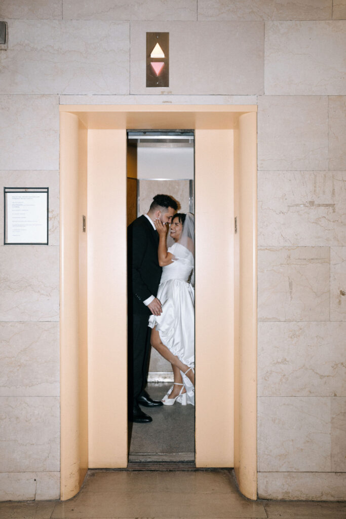 Bride and groom share an intimate moment in the elevator at Brooklyn City Hall during their NYC elopement, captured in a modern and romantic style.