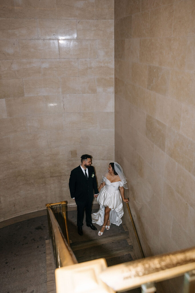 Bride and groom share a quiet moment on the grand staircase at Brooklyn City Hall during their NYC elopement