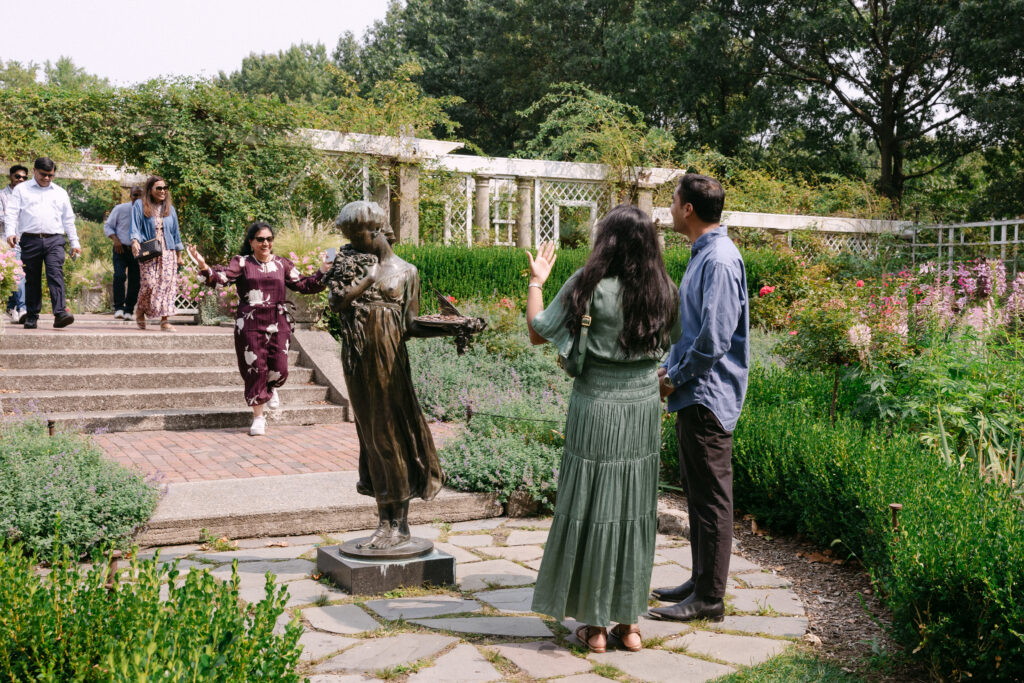 Family and friends celebrating a surprise proposal at the Rose Garden in Brooklyn Botanic Garden, captured by NYC engagement photographer.
