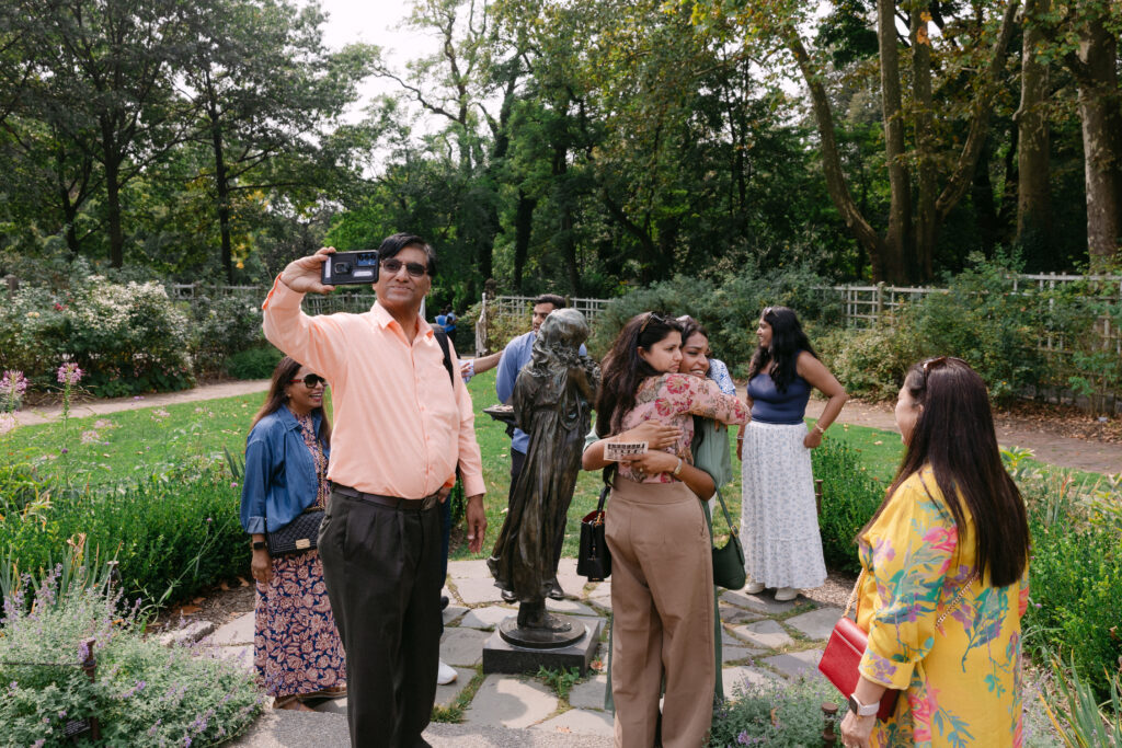 Friends and family laughing and celebrating after a surprise proposal at Brooklyn Botanic Garden, captured by NYC engagement photographer.
