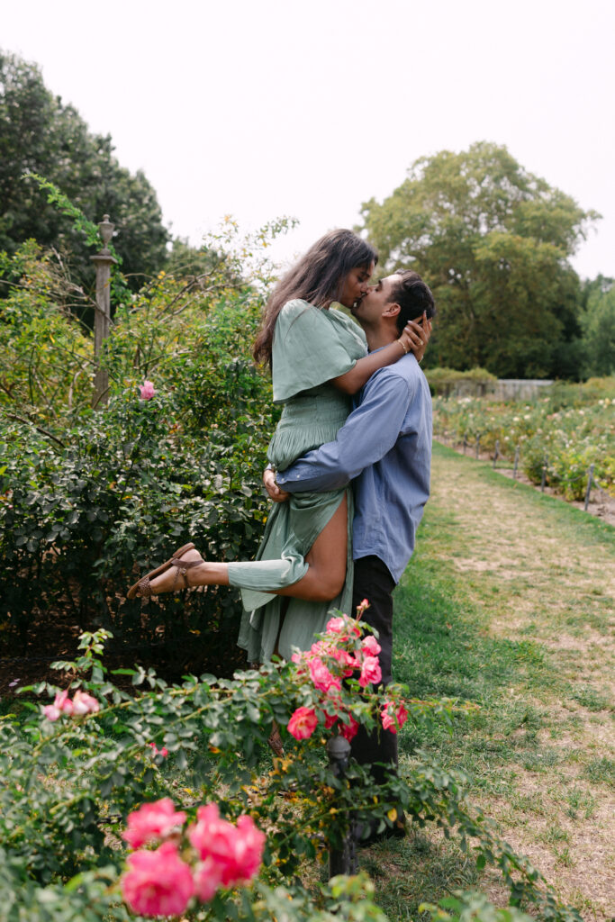 Engaged couple standing together in the Rose Garden at Brooklyn Botanic Garden, captured by NYC engagement and proposal photographer.
