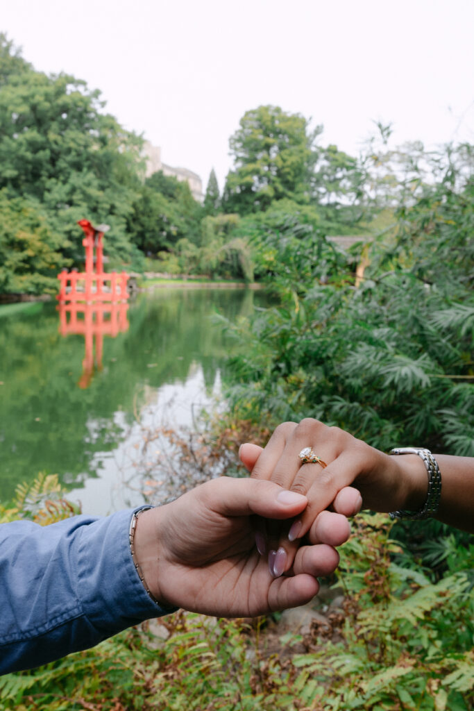 Close-up of engagement ring on her hand after a surprise proposal at Brooklyn Botanic Garden, photographed by NYC proposal photographer.
