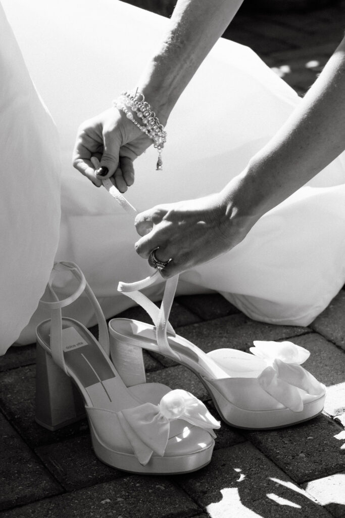 Bride putting on wedding shoes during a SoHo wedding, captured in a candid documentary style in New York City