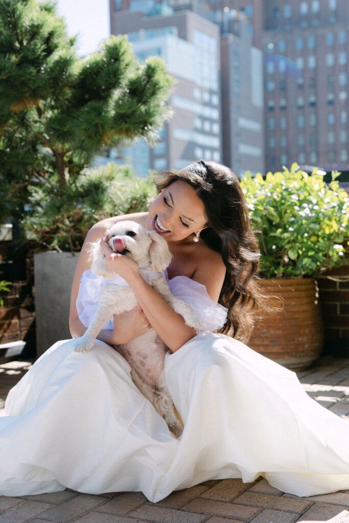 Bride sitting on a SoHo rooftop holding her dog during NYC wedding portraits