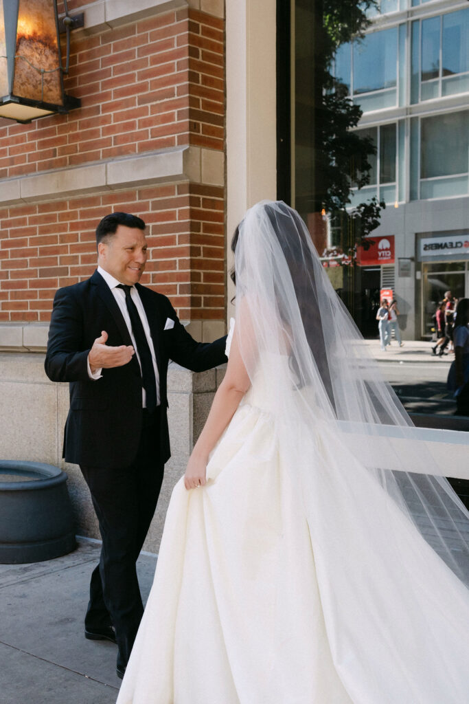 Bride and groom walking together in SoHo with flowing veil during NYC wedding portraits
