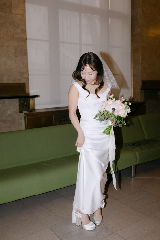 Bride standing with bouquet inside Manhattan City Hall
