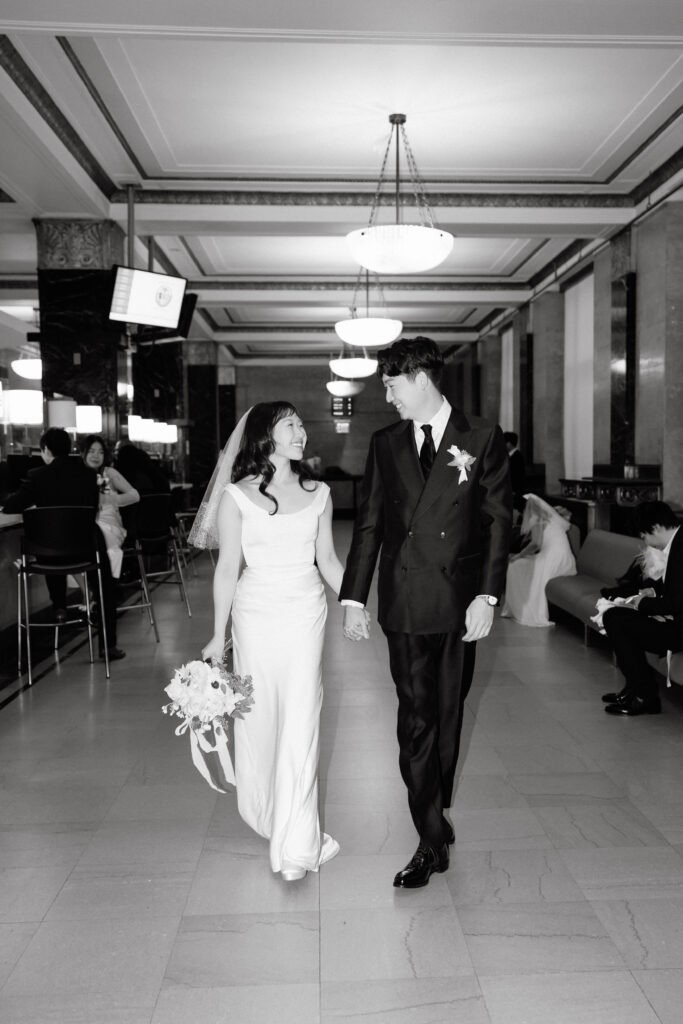 Couple walking together inside NYC City Hall hallway