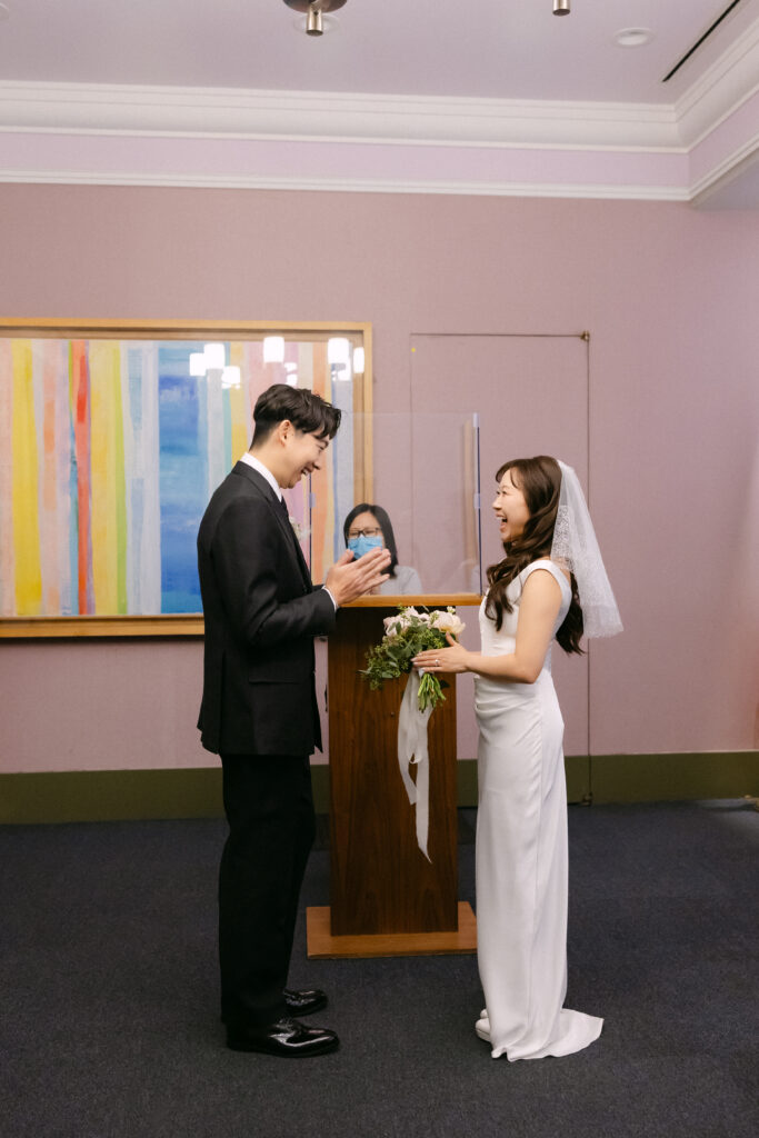 Couple standing facing each other inside NYC City Hall