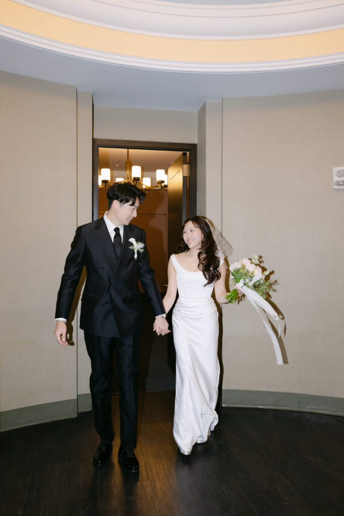Couple walking inside NYC City Hall after their ceremony