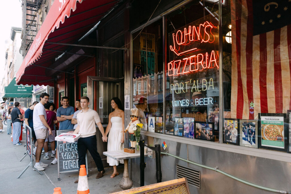engagement photos of a couple grabbing pizza during a west village engagement session in new york city