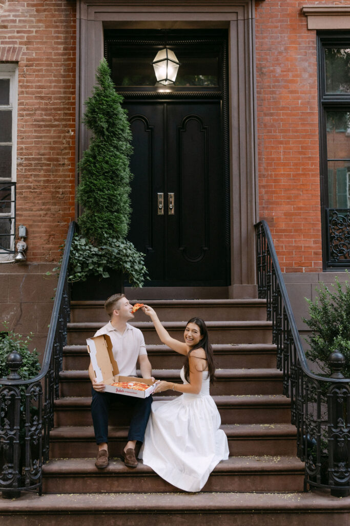 romantic engagement photos of a couple sitting on townhouse steps in the west village
