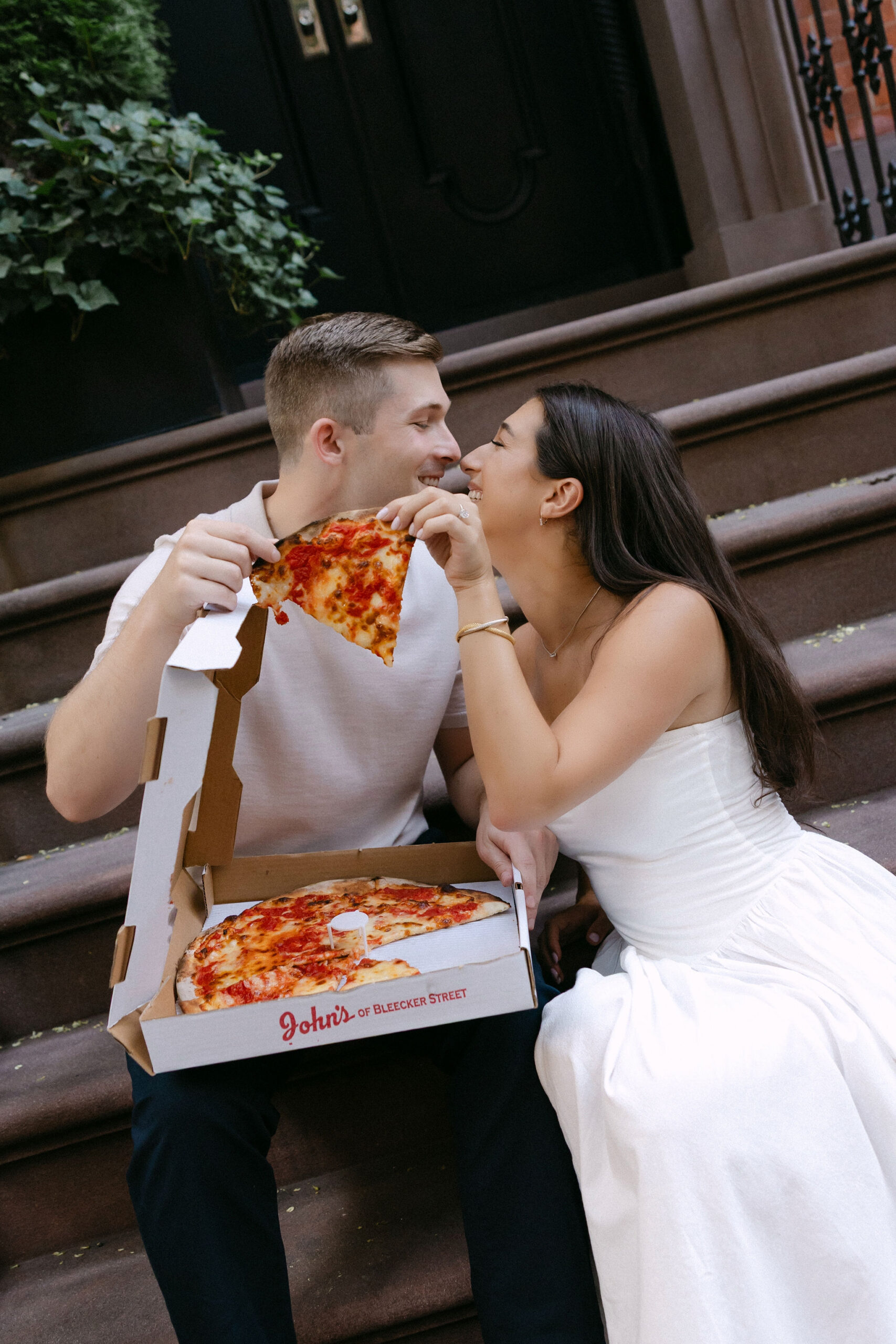 engagement photos of a couple sharing pizza during a relaxed west village session in new york city
