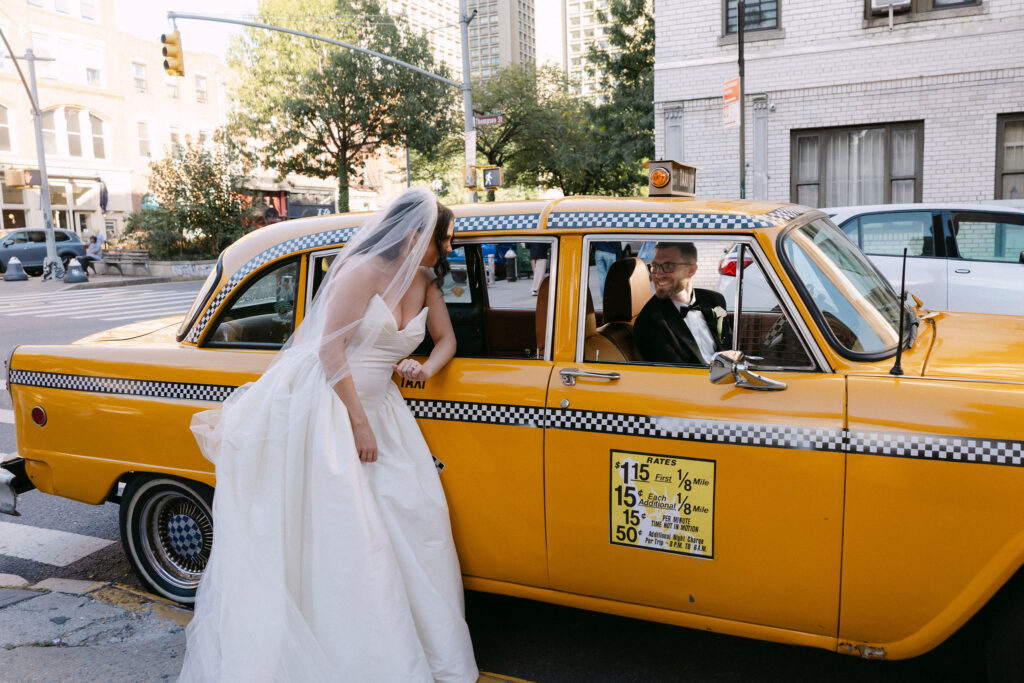 Bride stepping into a yellow taxi on a SoHo street during a New York City wedding