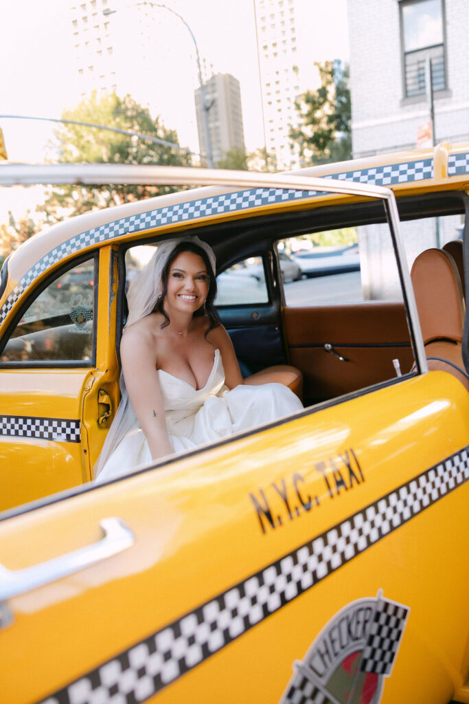 Bride sitting in the back seat of a yellow taxi during a SoHo wedding in New York City