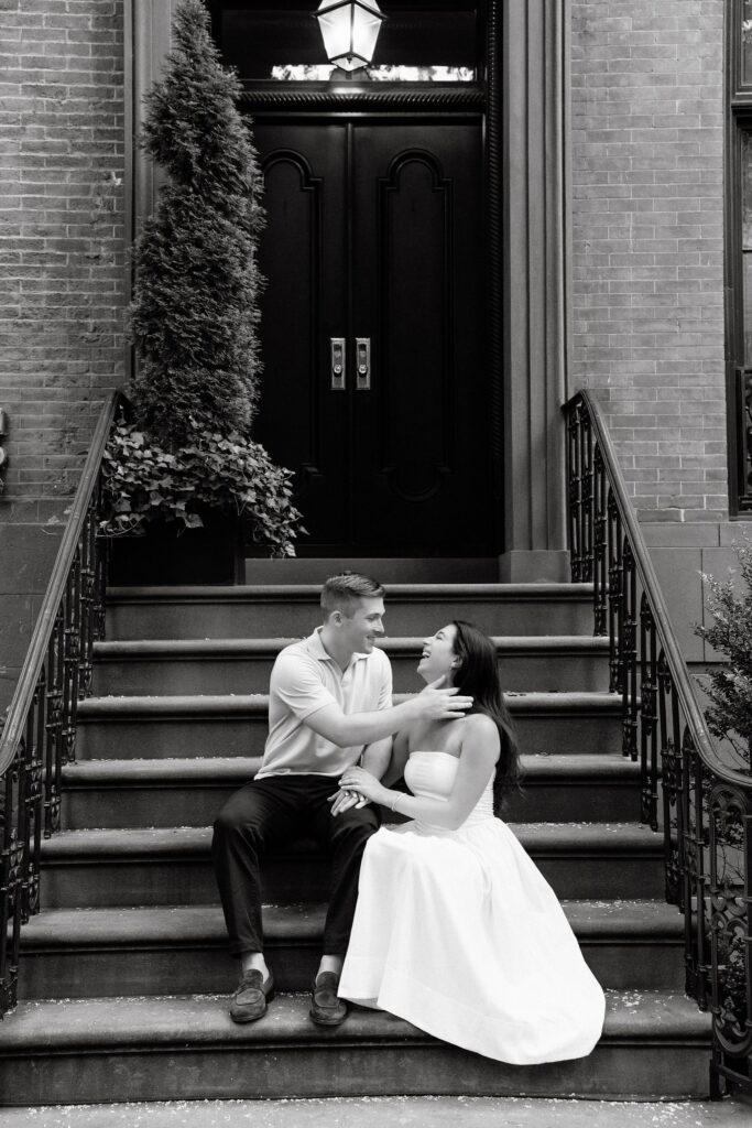 black and white engagement photos of a couple sitting together on townhouse steps in the west village