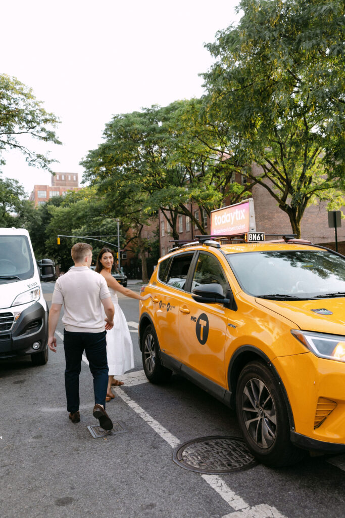 engagement photos of a couple walking down a west village street beside a yellow taxi in new york city
