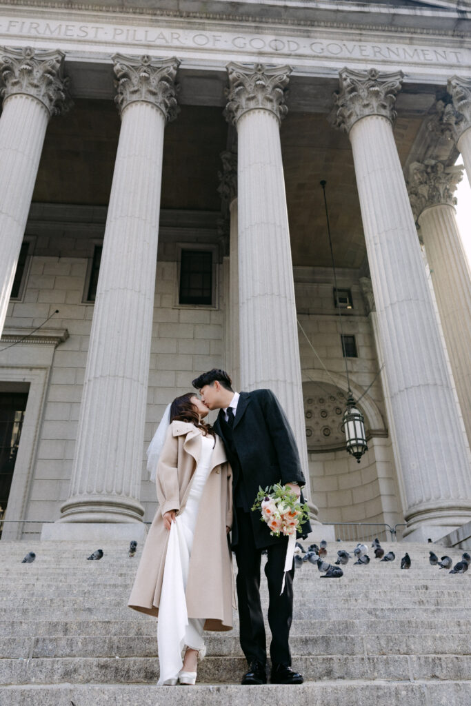 Editorial wedding portrait between the columns of NYC City Hall